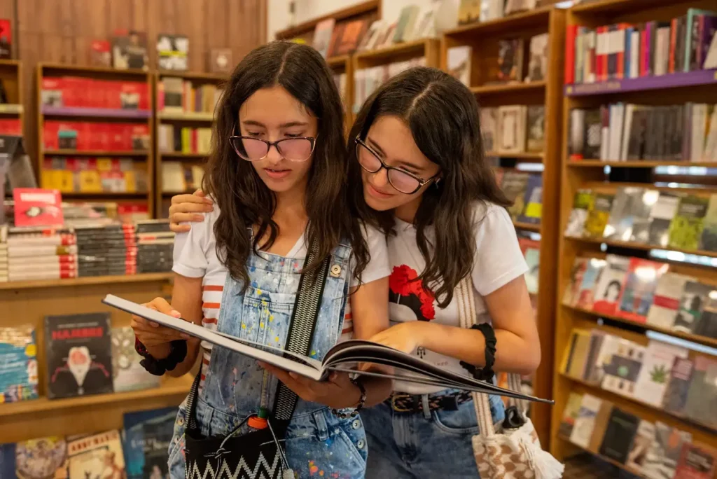 Dos mujeres jóvenes viendo un libro en la Fiesta del Libro 2023
