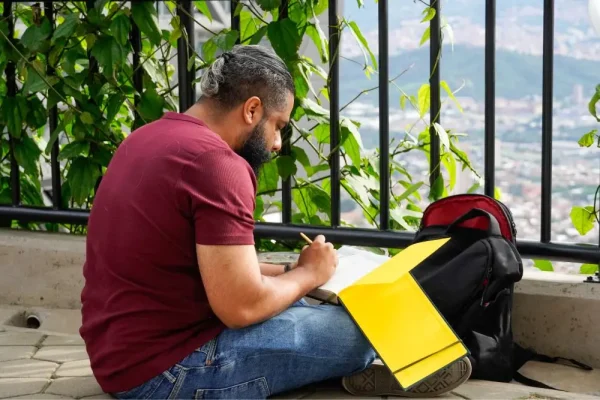 Hombre dibujando en un cuaderno - Parada Juvenil 2026